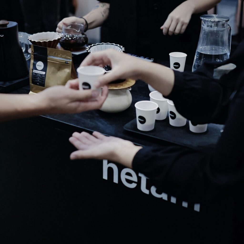 person buying coffee from a local roaster, emphasizing support for local communities