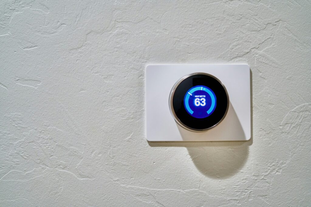 sleek smart thermostat mounted on a wall, displaying temperature settings for energy efficiency