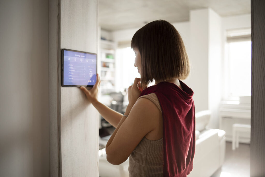Smart thermostat on a home wall, optimizing energy use for carbon neutrality,