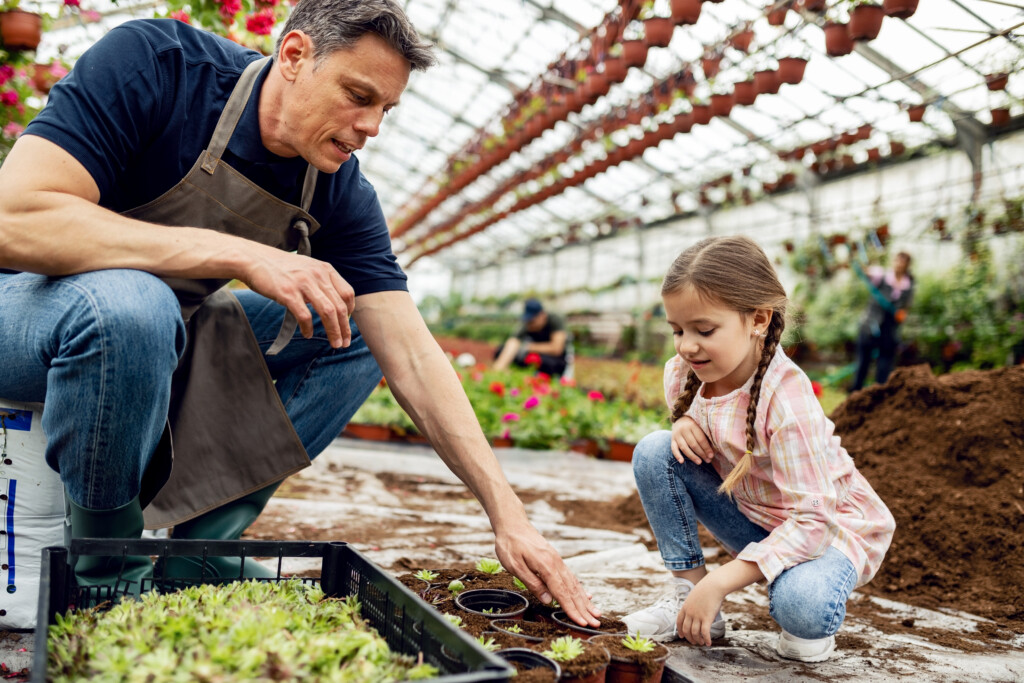 father-teaching-his-small-daughter-how-plant-flowers-plant-nursery